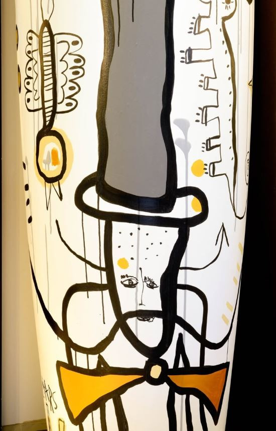 Columna con dibujos abstractos del Dandi en amarillo y negro en la recepción de Le Marquis 